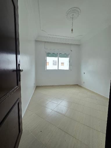 Chambre claire avec grande fenêtre d'un bien à Témara